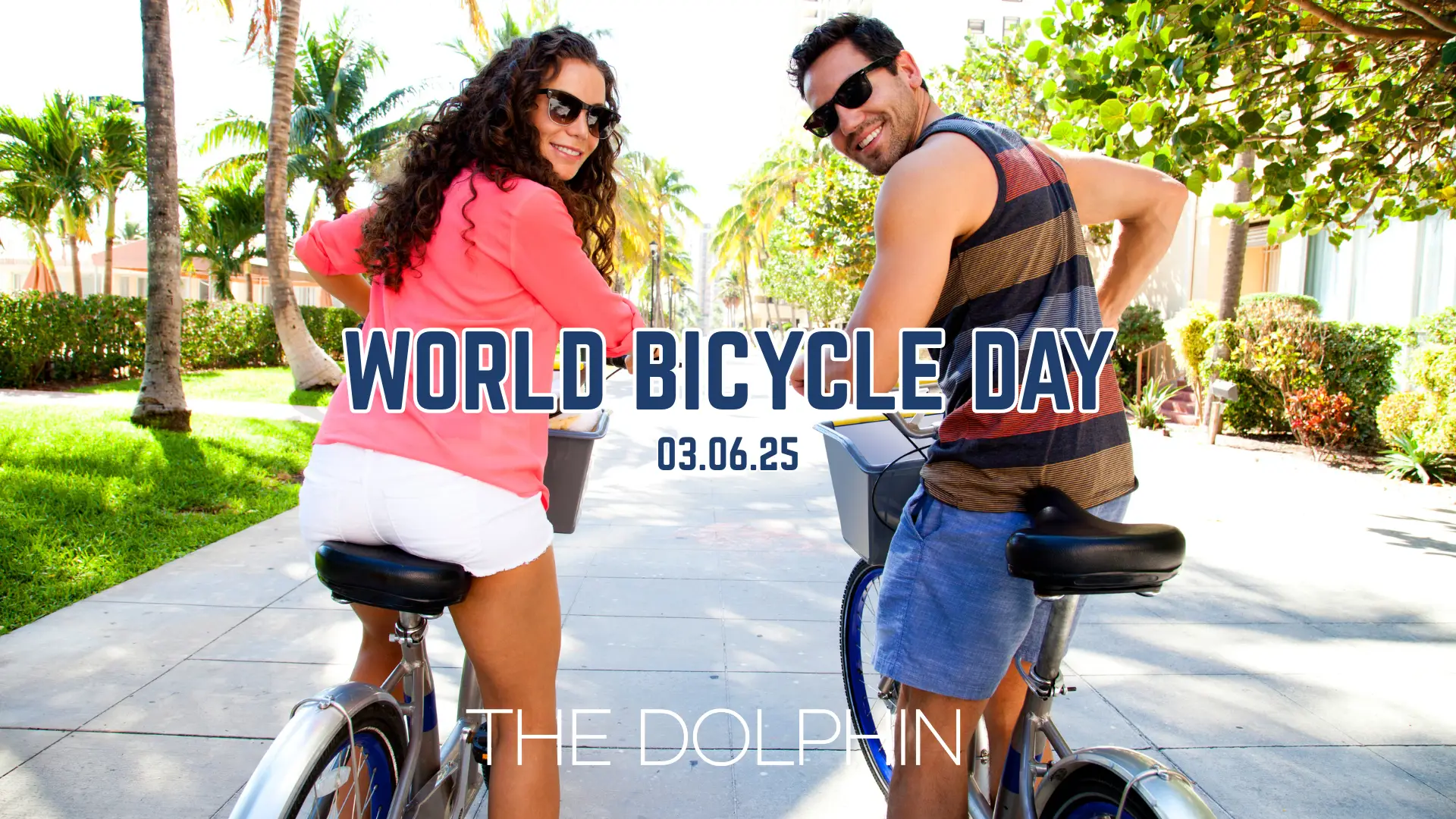 A couple riding bikes along a sunny path surrounded by greenery. They both look over their shoulders above the title text which reads 'World Bicycle Day, 3rd June 2025'